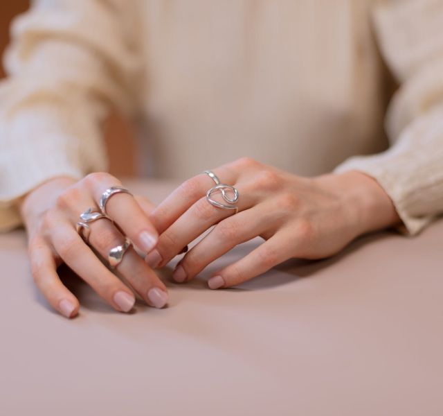 close up photo of a person wearing silver rings